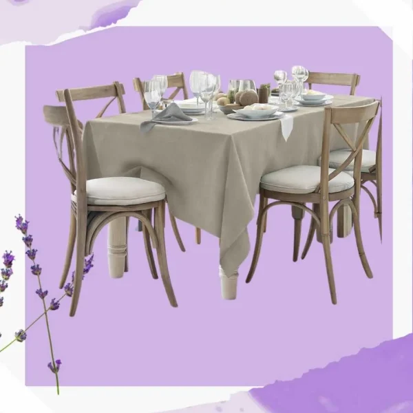 Mantel de color beige sobre una mesa de comedor de madera, preparada elegantemente para una comida