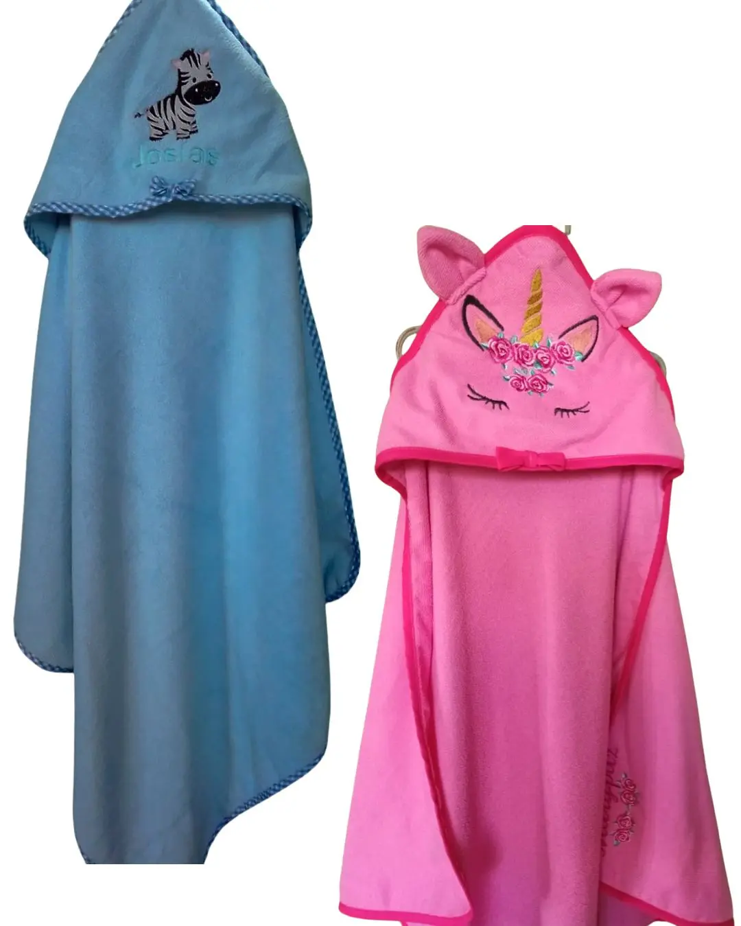Dos toallas con capucha infantiles: una azul con bordado de cebra y otra rosada con capucha de unicornio